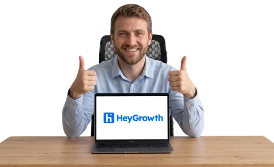 Happy person with laptop showing easy LinkedIn posting with HeyGrowth